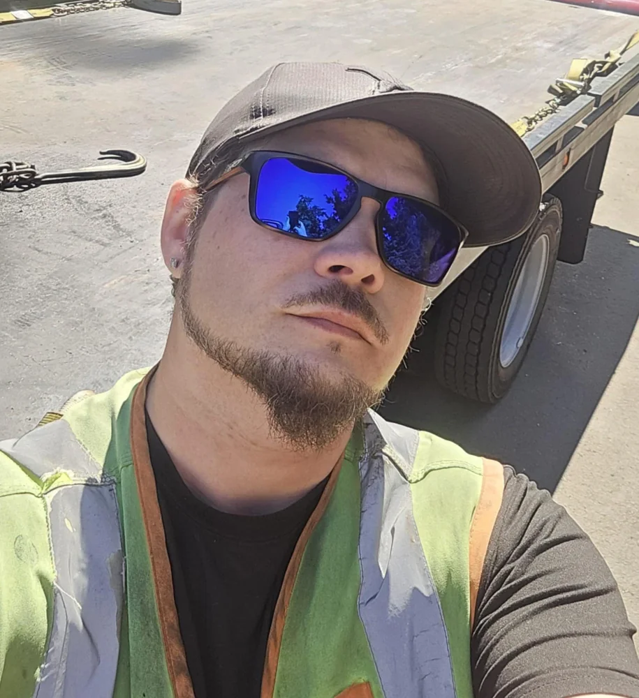 Jordan, JD’s Towing owner, beside his tow truck